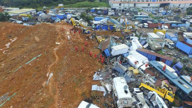 an aerial view shows rescuers walk among damaged vehicles to search for survivors at the site of a landslide which hit an industrial park on sunday in shenzhen guangdong province china december 22 2015 photo reuters