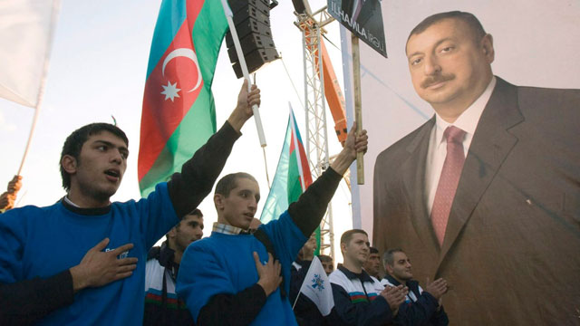 supporters of azerbaijan 039 s president ilham aliyev hold their national flags and a portrait of aliyev during an election rally in sumgait near the capital baku photo reuters file