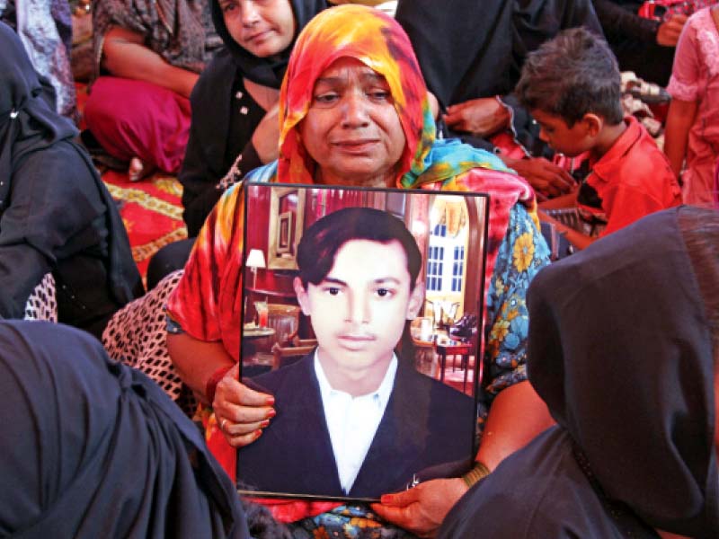 the family of a victim who was killed in the baldia factory fire three years ago holds his picture at a memorial service for the victims three years have passed since the country s worst industrial disaster but the court proceedings have yet to be initiated due to delays in the investigation process photo file