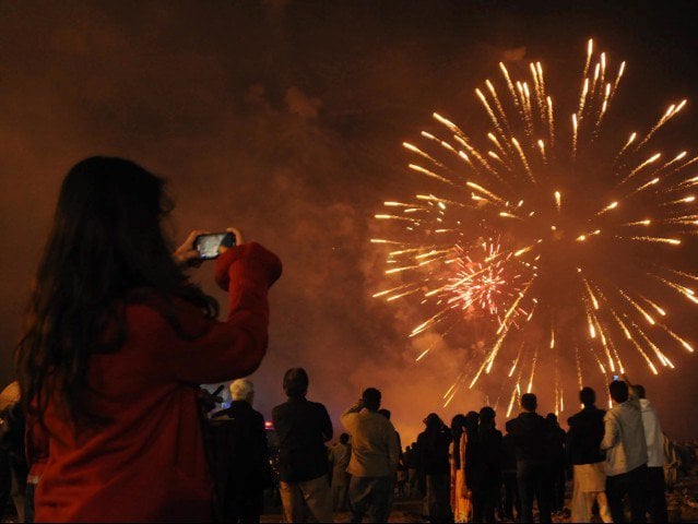 a girl tries to take a photograph of fireworks in karachi photo mohammad noman express