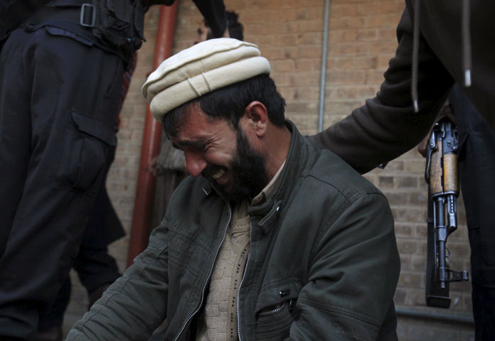 a man is comforted as he mourns the death of a relative after a suicide attack at a government office in mardan pakistan december 29 2015 photo reuters