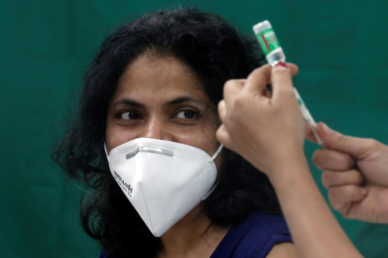 A healthcare worker looks on as a nurse prepares a dose of the AstraZeneca's COVISHIELD vaccine, during the coronavirus disease (COVID-19) vaccination campaign, at a medical centre in Mumbai, India, January 16, 2021. REUTERS