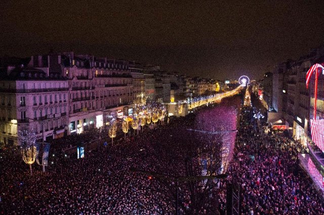 people gather on the champs elysees avenue before celebrating the new year in paris on december 31 2015 photo afp