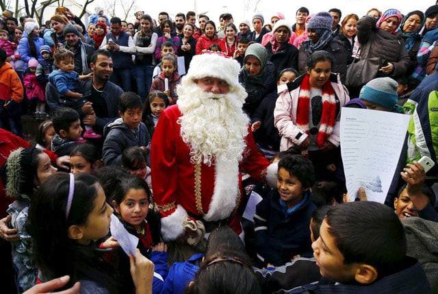 migrant children surround a volunteer dressed as santa claus during a christmas gathering organised by local relief organisation at the refugee camp in hanau germany photo reuters