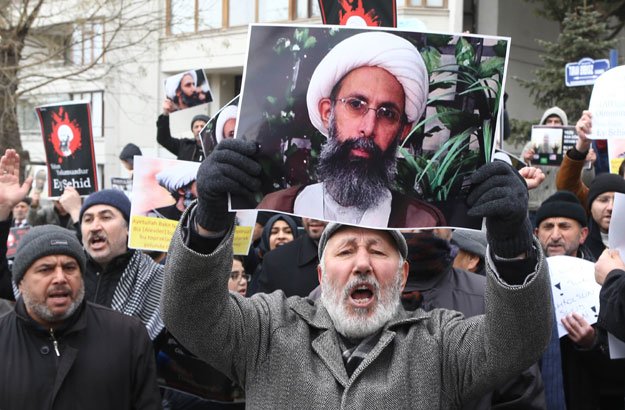iranian and turkish demonstrators hold pictures of shia cleric sheikh nimr al nimr as they protest outside the saudi embassy in ankara on january 3 2016 to protest against the execution by saudi arabia of a prominent shia cleric which they saw as a deliberate sectarian aggression photo afp