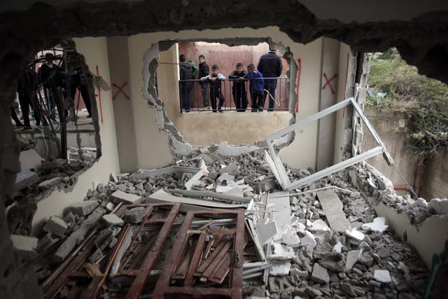 palestinian boys look into the house of bahaa allyan who was shot dead after he and an accomplice reportedly boarded a bus and shot and stabbed people at a jerusalem in october last year after it was partially demolished by israeli forces in the east jerusalem palestinian neighbourhood of jabal mukaber on january 4 2016 photo afp