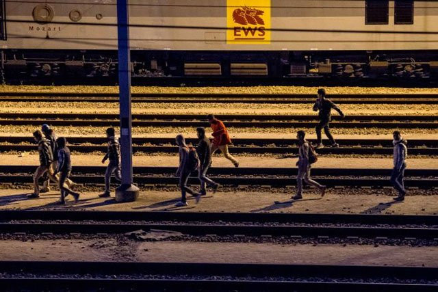 migrants walk along railway tracks at the eurotunnel terminal in calais frethun photo afp migrants walk along railway tracks at the eurotunnel terminal in calais frethun photo afp