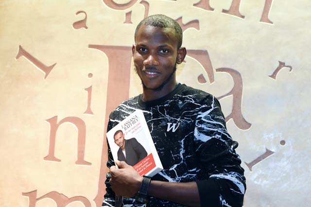 a picture taken on december 16 2015 shows lassana bathily the employee of the hyper cacher jewish supermarket in paris who helped shoppers hide in a cold storage room from an islamist gunman who attacked the store on january 9 2015 posing with his book quot je ne suis pas un heros quot i am not a hero lassana bathily was an undocumented migrant from mali until he became an unlikely hero by saving shoppers 039 lives during the jihadist attack on a jewish supermarket in paris a year ago the narrative of a muslim saving jews from a jihadist made him a positive symbol of france 039 s diversity bathily was just a few minutes from the end of his shift at the supermarket unpacking frozen items in the basement when he heard a flurry of gunfire upstairs and saw around a dozen people fleeing down the stairs photo afp