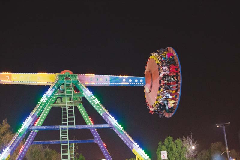 thrill seeking riders cling to their safety harness as discovery one of aladin amusement park s most popular attractions takes them on an upside down ride photo arif soomro