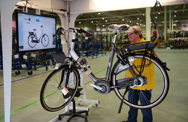 this file photo taken on december 10 2015 shows a worker testing an electric bicycle before shipping at dutch bicycle manufacturer gazelle in dieren the netherlands photo afp