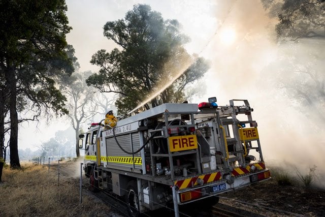 this handout photo taken on january 7 2016 and released by the department of fire and emergency services dfes shows firemen tackling a bushfire burning near waroona some 110 kilometres south of perth photo afp