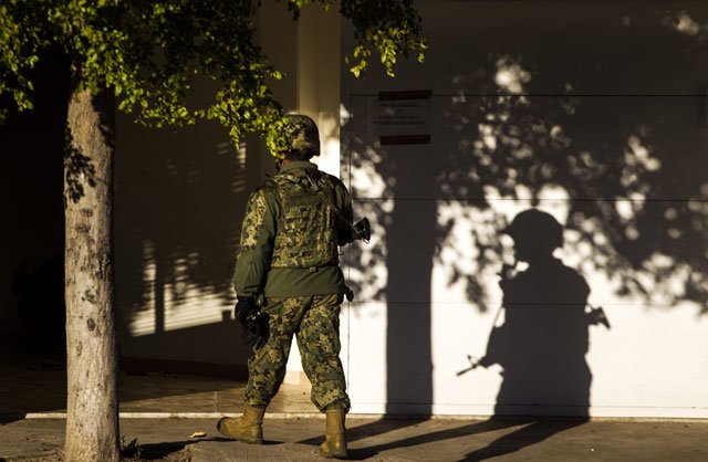 a marine stands guard on january 9 2016 in front of the house where five gang suspects were killed in the military operation which resulted in the recapture of joaquin quot el chapo quot guzman in los mochis sinaloa state mexico photo afp