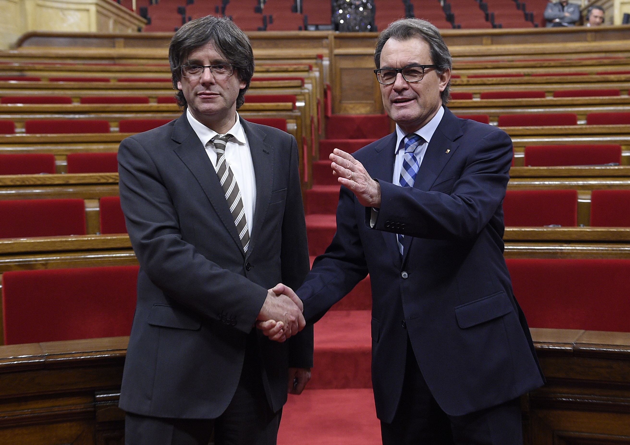 new elected president of the catalan government carles puigdemont l is congratulated by former president artur mas at the end of an investiture debate for the catalan government 039 s presidency at the parliament of catalonia in barcelona on january 10 2016 the majority secessionist lawmakers in catalonia 039 s parliament voted in a new leader today tasking him to oversee the wealthy region 039 s breakaway from spain in a last minute show of unity after months of bitter infighting carles puigdemont was elected regional president with 70 votes for 63 against and two abstentions giving catalonia 039 s high profile independence movement a fresh lease of life photo afp