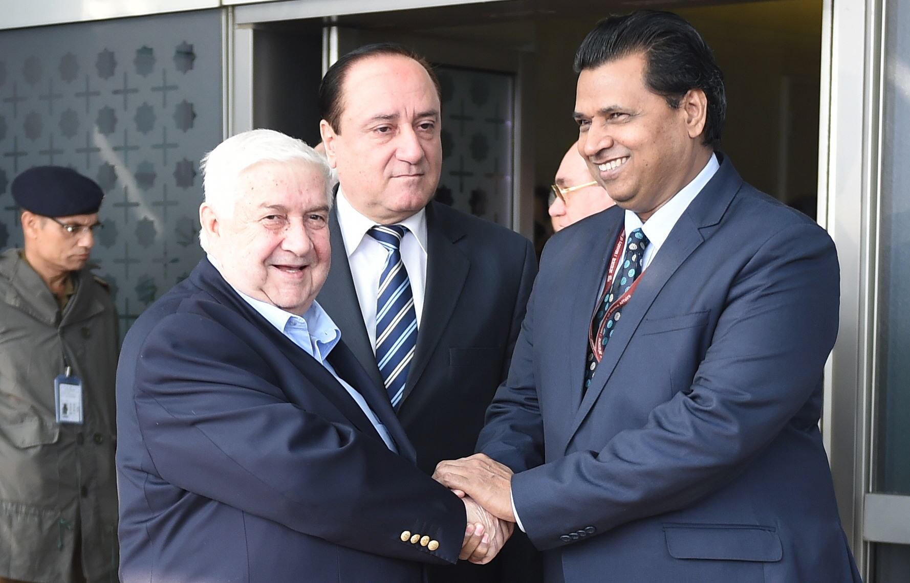syrian deputy prime minister and minister of foreign affairs walid al moualem l shakes hand with joint secretary satbir singh r upon his arrival at the indira gandhi international airport in the indian capital new delhi on january 11 2016 moualem is on an official visit to india photo afp