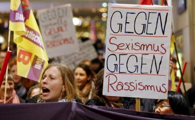 women shout slogans and hold up a placard that reads 039 against sexism   against racism 039 as they march through the main railways station of cologne photo reuters