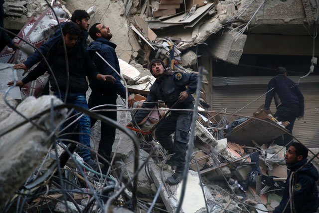 syrians and civil defence workers search for victims amid the rubble of a destroyed building following air strikes on the eastern ghouta town of douma a rebel stronghold east of the capital damascus on january 10 2016 photo afp