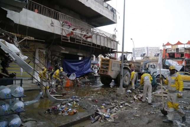 file photo of municipal workers cleaning up the site of a car bomb attack in baghdad photo file