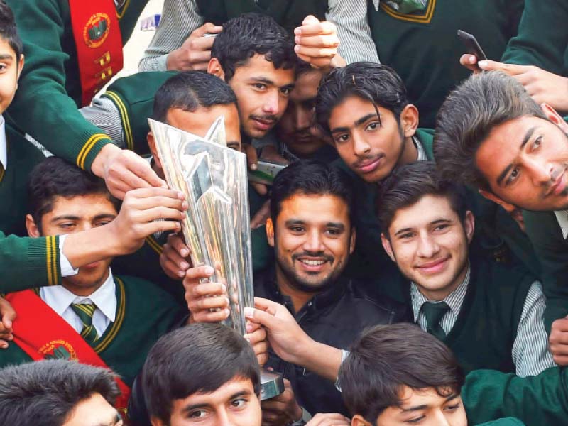 odi skipper azhar ali and students of aps peshawar pose with the icc world t20 trophy photo afp