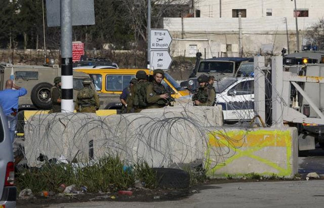 israeli soldiers stand guard near the scene where israeli military said a palestinian who tried to stab a soldier was shot dead by israeli troops in the west bank city of hebron january 12 2016 photo reuters israeli soldiers stand guard near the scene where israeli military said a palestinian who tried to stab a soldier was shot dead by israeli troops in the west bank city of hebron january 12 2016 photo reuters