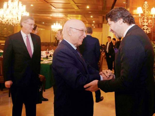 sartaj aziz greets the afghan deputy foreign minister as the us special envoy looks on photo afp