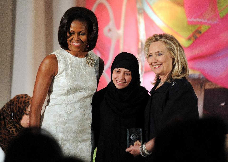 us first lady michelle obama l and presidential hopeful hillary clinton r pose with samar badawi of saudi arabia as she receives the 2012 international women of courage award in washington on march 8 2012 photo afp