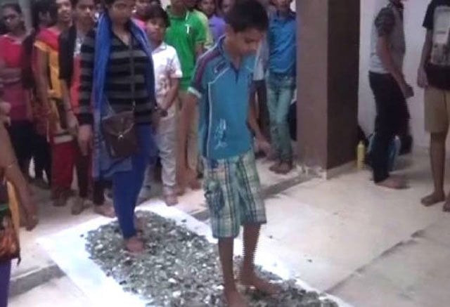 this still image taken from a video shows indian students walking barefoot on broken glass at a private coaching centre in the western indian state of gujarat photo courtesy abp live this still image taken from a video shows indian students walking barefoot on broken glass at a private coaching centre in the western indian state of gujarat photo courtesy abp live