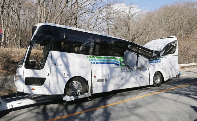 a crashed bus is pulled by a tow truck in karuizawa in nagano prefecture central japan on january 15 2016 after it ran off a mountain road photo afp