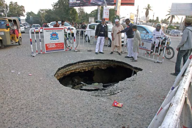 a crater on shaheed e millat road caused severe traffic jam on friday the huge hole emerged on the main road as the sewerage line beneath the road was damaged due to organic gases inside it photo athar khan express a crater on shaheed e millat road caused severe traffic jam on friday the huge hole emerged on the main road as the sewerage line beneath the road was damaged due to organic gases inside it photo athar khan express