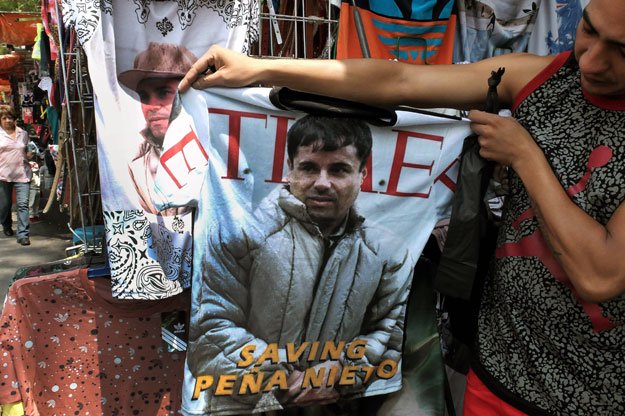 a vendor shows a t shirt with the face of joaquin quot el chapo quot guzman loera for sale in the popular and dangerous tepito neighborhood in mexico city on july 20 2015 photo afp