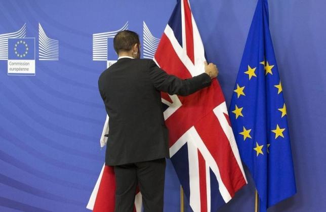 an employee at the european commission adjusts a british flag ahead of the meeting between prime minister david cameron and european commission president jean claude juncker in brussels october 15 2015 photo reuters
