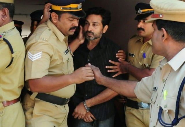 indian police personnel escort murder suspect muhammad nisham centre accused of fatally wounding a security guard by driving into him with his car at the judicial magistrate 039 s court in thrissur on march 11 2015 photo afp