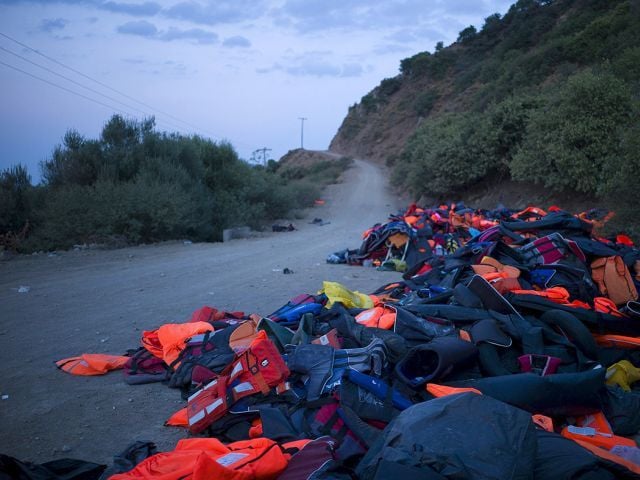 life jackets and deflated dinghies left behind by refugees and migrants are seen on the roadside near a beach on lesbos photo reuters