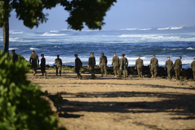 a group of marines walk the beach outside the haleiwa incident command post in haleiwa hawaii during search efforts for 12 missing marines in this handout photo taken january 18 2016 photo reuters