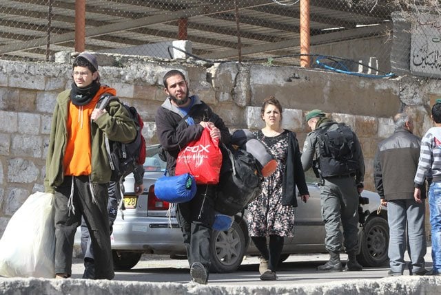 jewish settlers carry their belongings as they are evacuated by israeli security forces from two homes in the heart of the west bank city of hebron on january 22 2016 the day after they entered the buildings sparking violent clashes over disputed ownership claims photo afp