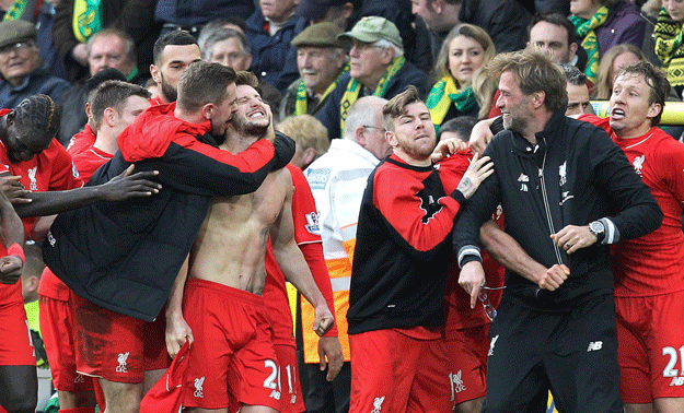 adam lallana celebrates scoring late winning goal with teammates and manager jurgen klopp at carrow road in norwich england on january 23 2016 photo afp