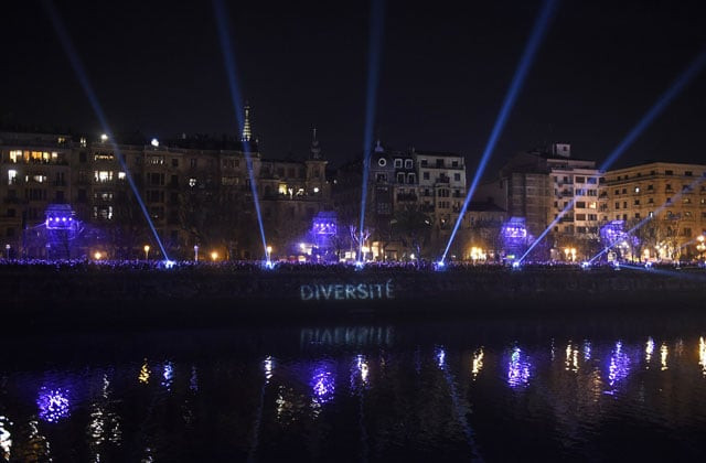 people line the river banks during a performance dubbed quot bridge of cohabitation quot created by the artist hansel cereza in the northern spanish basque city of san sebastian on january 23 2016 photo afp