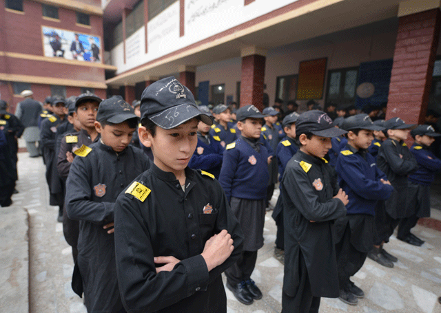 this photo taken on january 22 2016 shows pakistani students attending a school assembly at a government primary school in peshawar a debate over arming teachers has surged in pakistan once more days after assistant chemistry professor syed hamid husain opened fire on the taliban gunmen who stormed the university campus where he worked photo afp