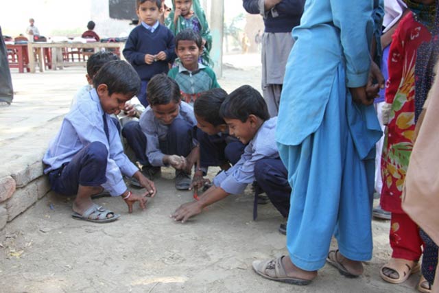 children playing marbles at break time at alyousif school