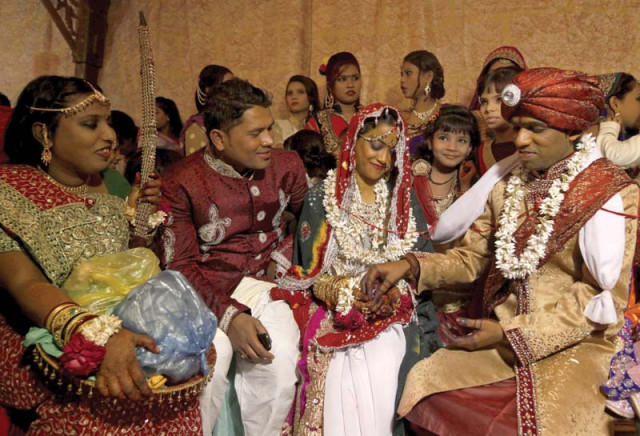 a bride and groom wearing traditional handmade garlands wait for their wedding to start while another couple performs a wedding ritual during the mass marriage ceremony photos reuters a bride and groom wearing traditional handmade garlands wait for their wedding to start while another couple performs a wedding ritual during the mass marriage ceremony photos reuters