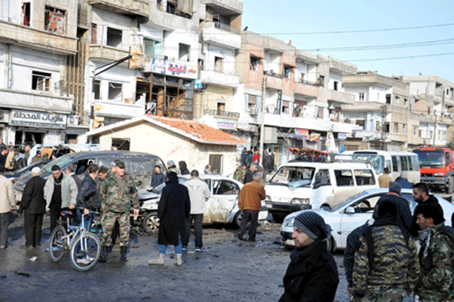 people inspect the site of a double bomb attack in the government controlled city of homs syria in this handout picture provided by sana on january 26 2016 photo reuters sana