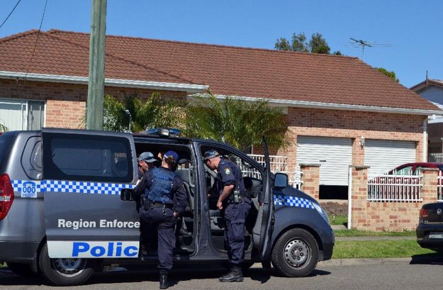 police officers stand guard outside a house during a counter terrorism raid in the guildford area of sydney on september 18 2014 photo afp