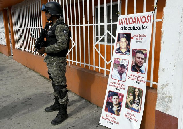 a civil forces police stands next to a banner with pictures of five youngsters who went missing past january 11 in tierra blanca community veracruz state mexico on january 25 2016 photo afp a civil forces police stands next to a banner with pictures of five youngsters who went missing past january 11 in tierra blanca community veracruz state mexico on january 25 2016 photo afp