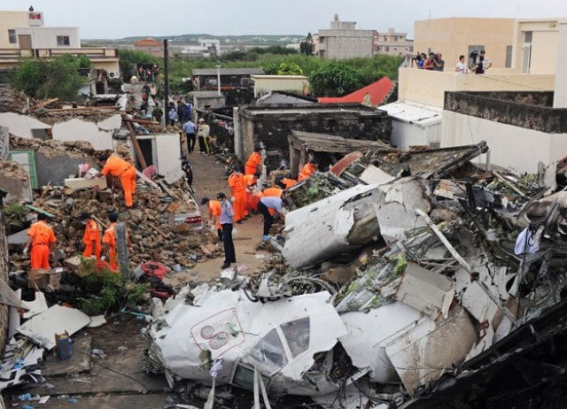 this picture taken on july 24 2014 shows rescue workers and firefighters searching through the wreckage where transasia airways flight ge222 crashed the night before near the airport at magong on the penghu island chain on july 24 2014 photo afp this picture taken on july 24 2014 shows rescue workers and firefighters searching through the wreckage where transasia airways flight ge222 crashed the night before near the airport at magong on the penghu island chain on july 24 2014 photo afp