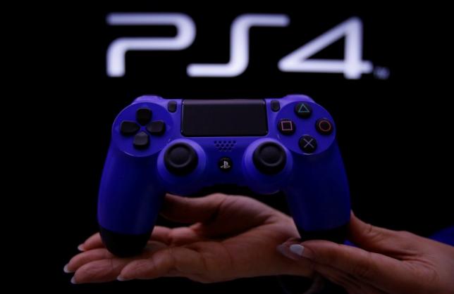 a staff at the playstation 4 launch event poses with the playstation 4 039 s game controller before its domestic launch event at the sony showroom in tokyo february 21 2014 photo reuters