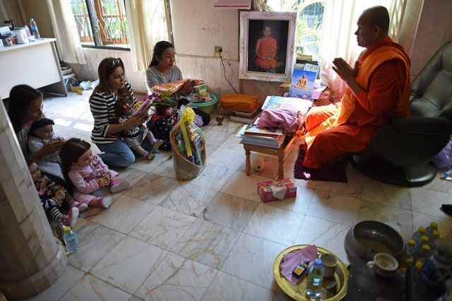 this picture taken on january 28 2016 shows a buddhist monk leading prayers during a religious ceremony for doll collector producer and trader mananya boonmee 2nd r friend natsuda jantaptim 2nd l a student and helper l and their quot luuk thep quot child angel dolls at the bangchak buddhist temple in nonthaburi on the outskirts of bangkok photo afp