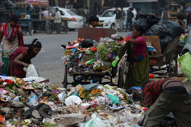 this photo taken on january 31 2016 shows indian ragpickers looking for useable items from heaps of garbage strewn on a road in new delhi photo afp