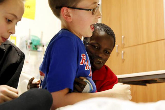 dunia sibomana 8 who was attacked two years ago by chimpanzees in his village in the democratic republic of congo plays with eian 12 and grace 10 of his host family in his room at stony brook children 039 s hospital new york january 29 2016 photo reuters