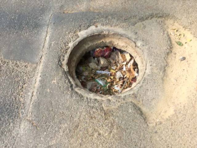 an open manhole filled with junk on saba avenue dha photo express