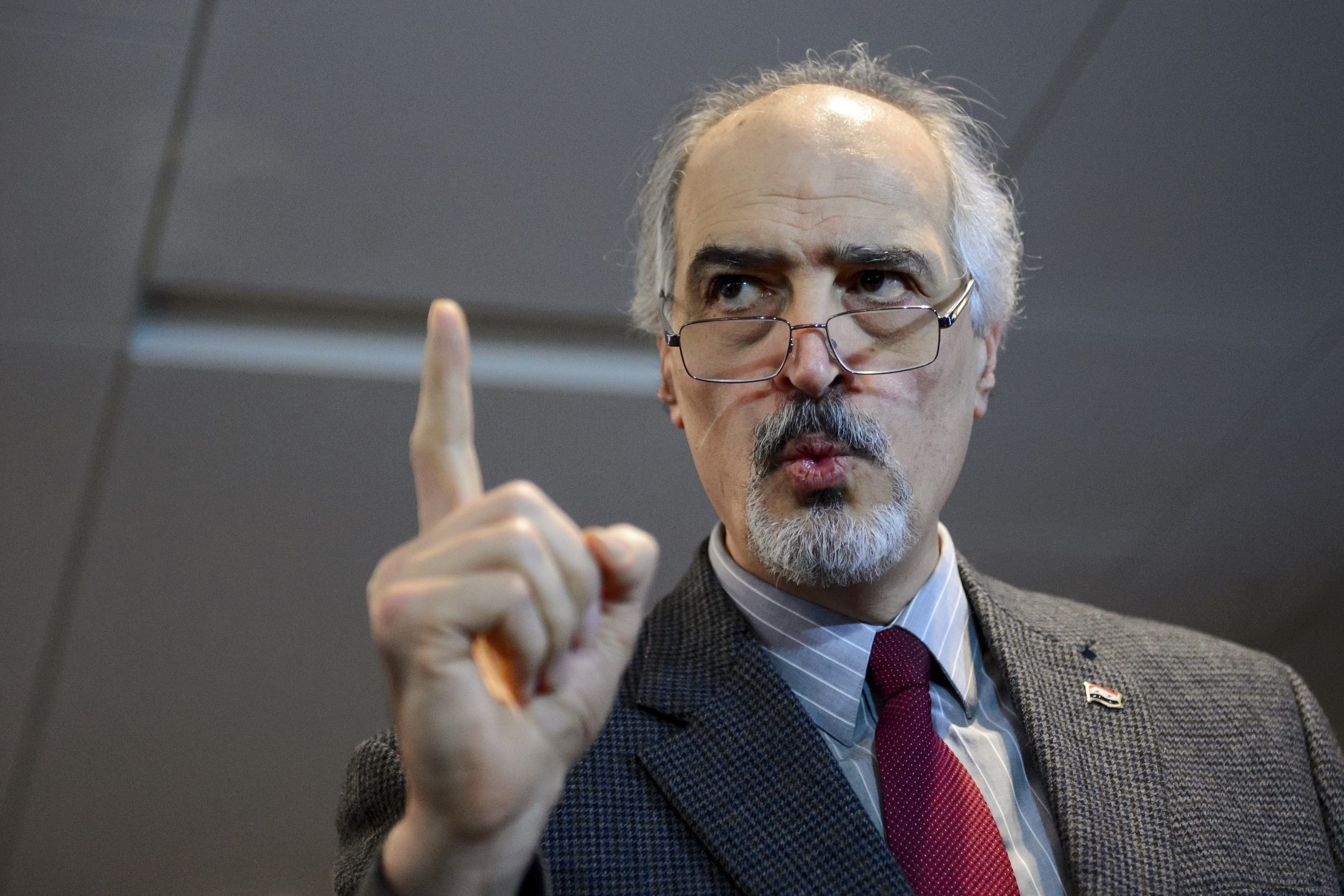 syrian ambassador to the un and head of the government delegation bashar al jaafari gestures as he holds a press conference during the syria peace talks in geneva on january 31 2016 photo afp