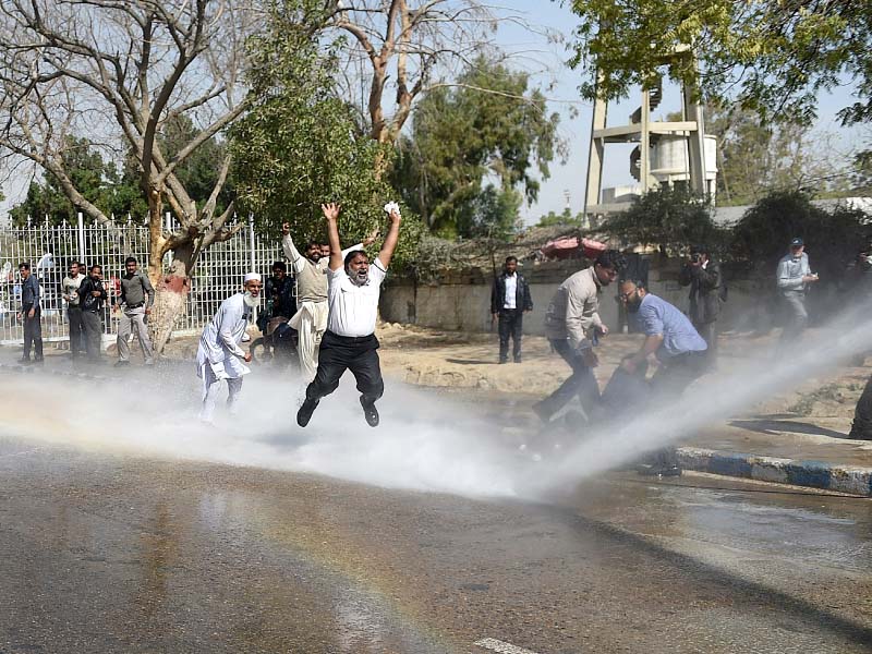 pia employees shout slogans as police use a water cannon on them during a protest near the karachi airport photo afp